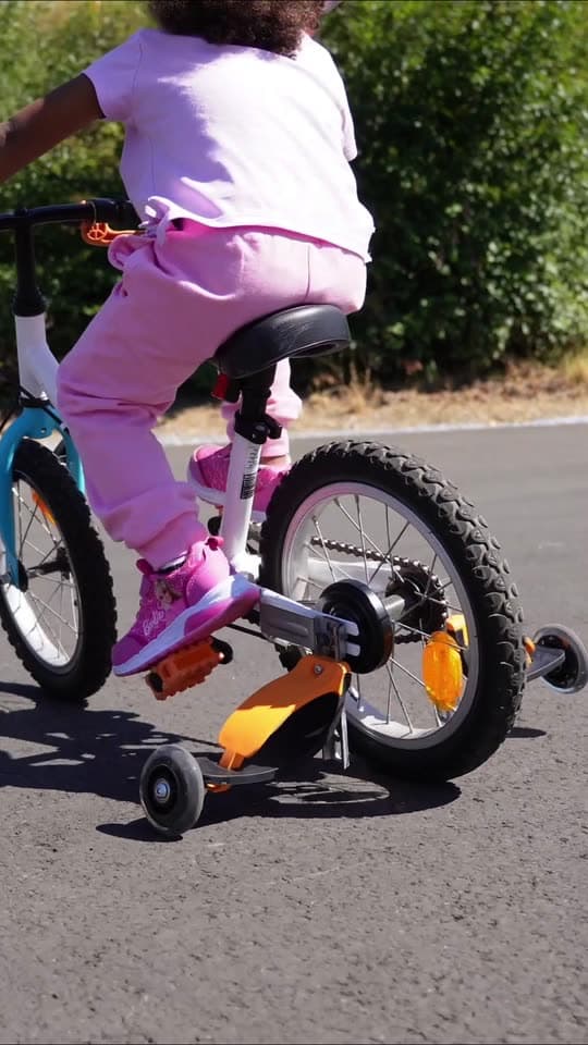Enfant apprenant le vélo avec les stabilisateurs flexibles Baswil