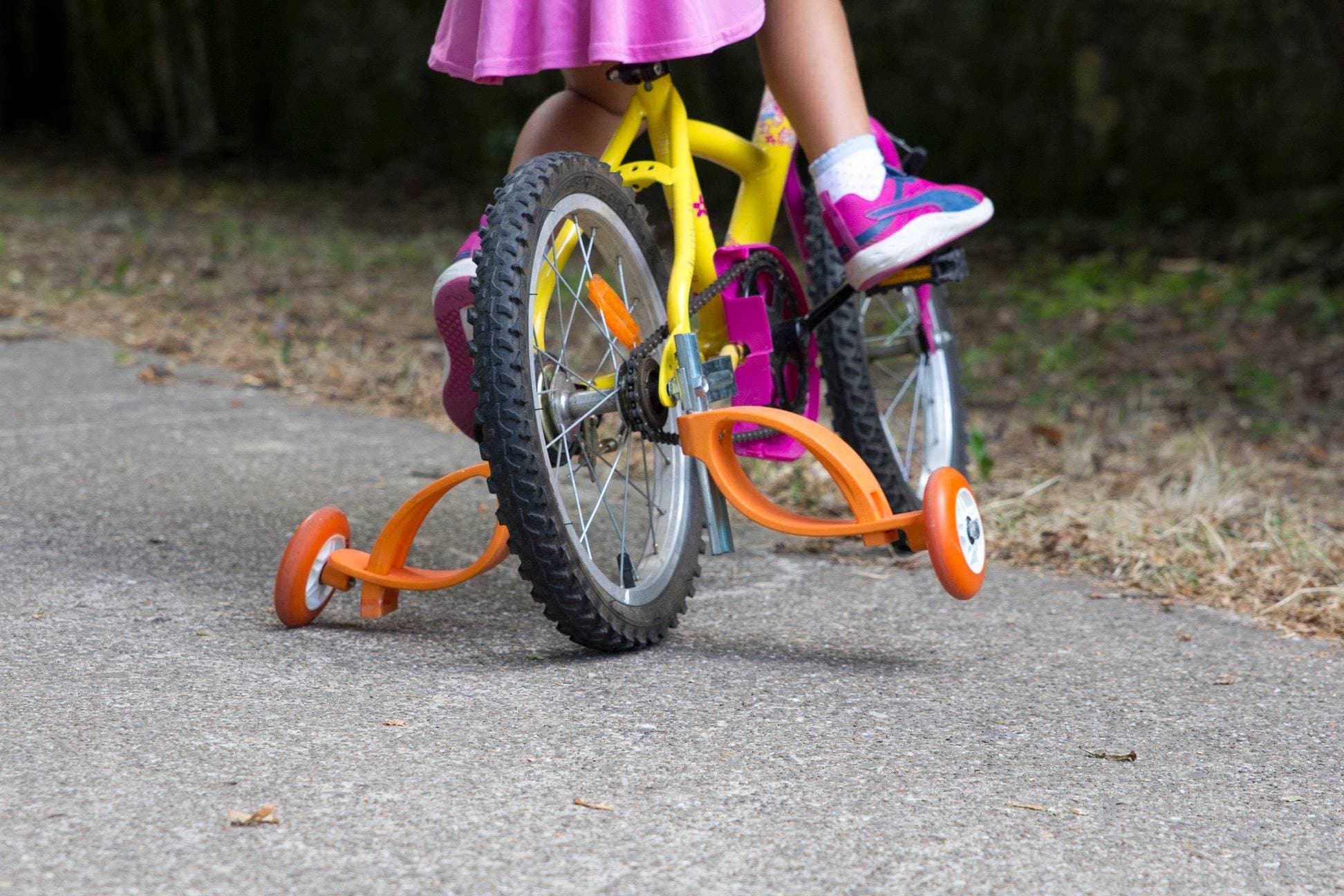 Child on a bike with classic training wheels